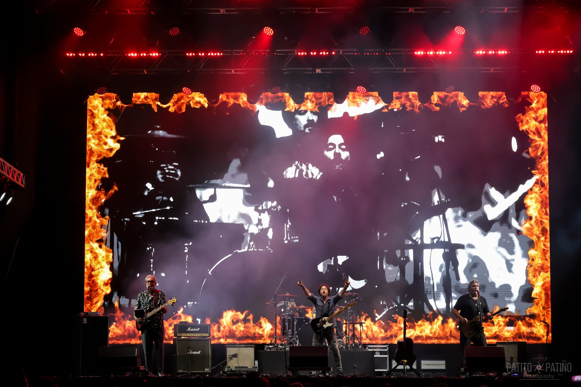 PAIKO en concierto, con los músicos frente a una gran pantalla y luces rojas